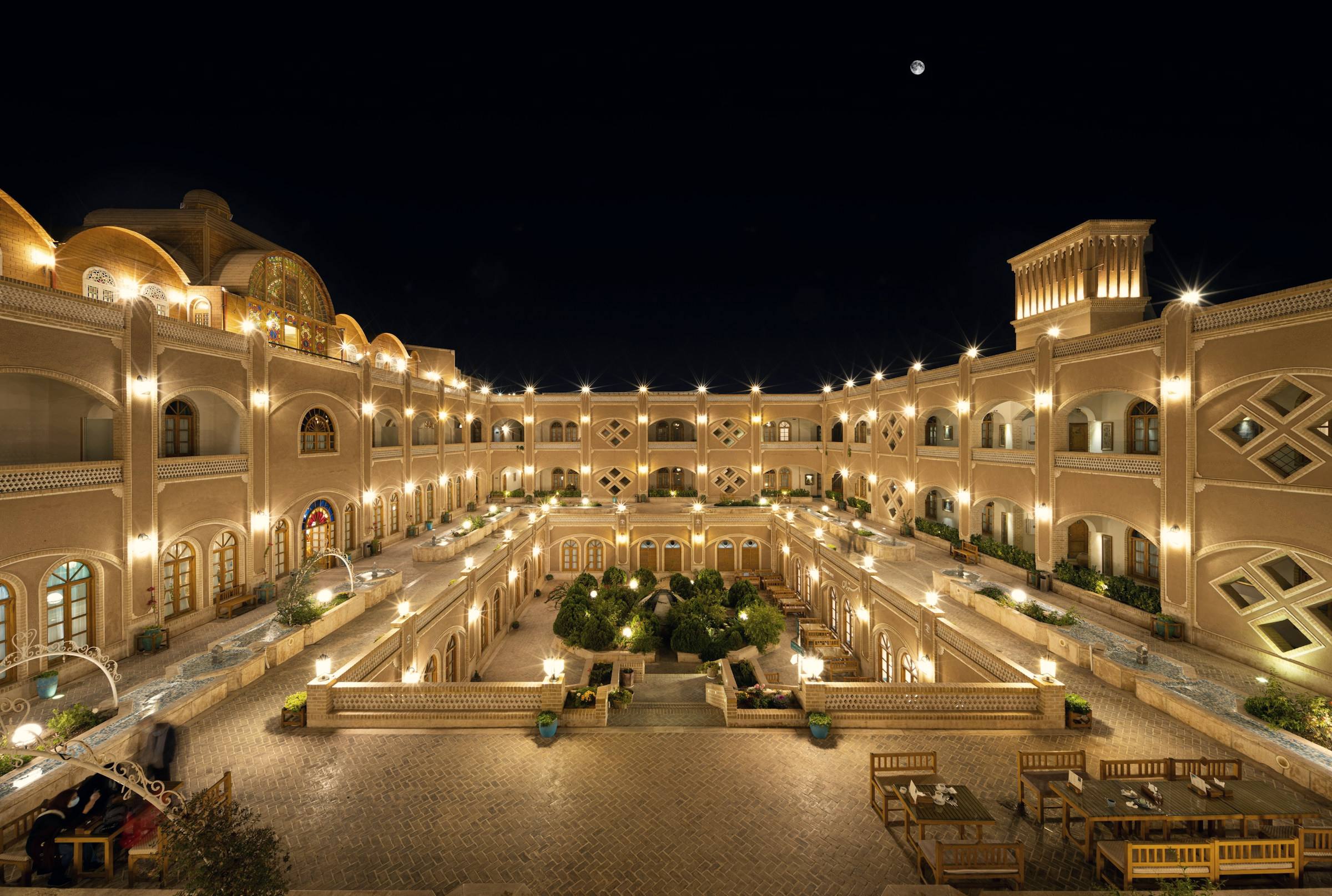 A palace-hotel courtyard lit up at night